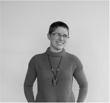 Black-and-white photo of Melody, a white woman with short hair and glasses, smiling to the side.