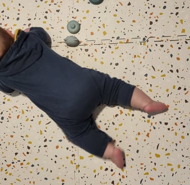 a baby is laying on a floor with a teddy bear