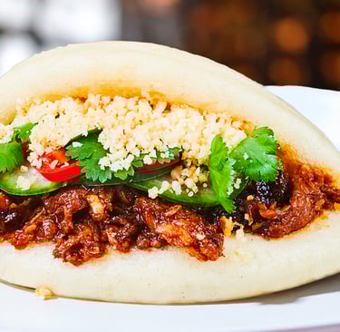 vegan bao bun stuffed with korean vegan meat on a plate