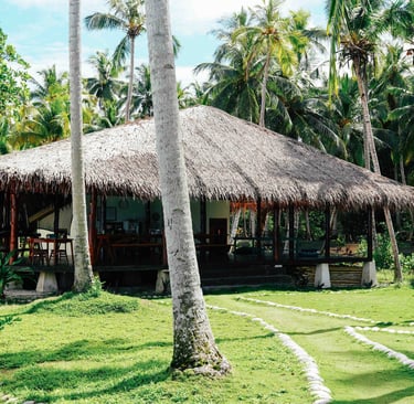 Open-air dining pavilion at Toska eco-resort surrounded by tropical palm trees