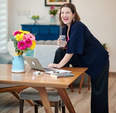 megan swan wellness coach for women standing at table with water