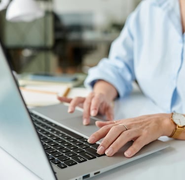 Žena u kancelariji koristi laptop za upravljanje veb sajtom i digitalnim marketingom svoje kompanije