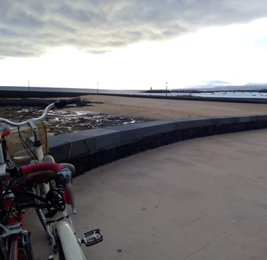 a bicycle parked on a concrete wall next to a body of water