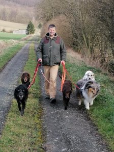 Martin Lindhof in der Feldmark mit fünf Hunden beim Gassi. Alle Hunde gehen leinenführig.