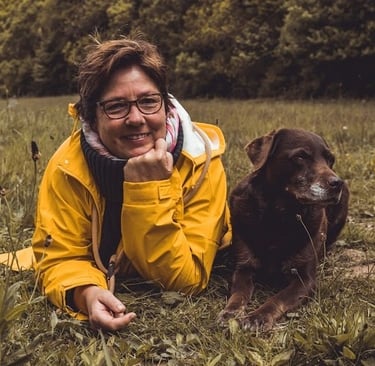 Marion Lindhof von Hunde Freude mit ihrer verstorbenen Labradorhündin Amy auf einer Wiese.