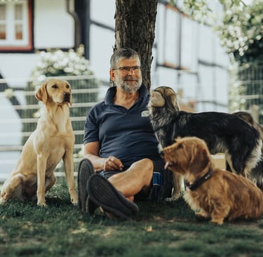 Martin Lindhof im Garten vom Hunde Hotel Hunde Freude mit drei lieben Hunden.