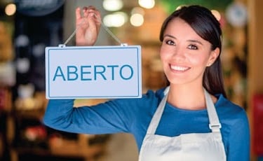 imagem de uma jovem segurando uma placa escrita a palavra ABERTO .
