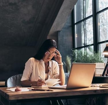 imagem ilustra uma empresária sentada na cadeira trabalhando em Home office.
