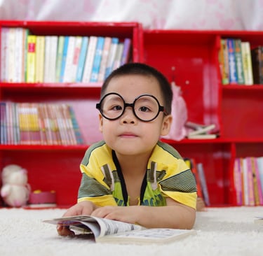 imagem de um menino de seis anos deitado num tapete lendo um livro