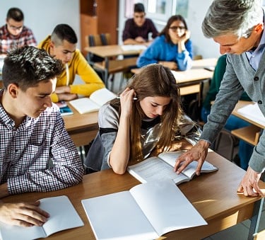 imagem de uma sala de aula com alunos interagindo com o professor