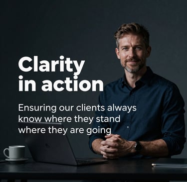 A large construction site featuring multiple high cranes, with numerous workers wearing high-visibility clothing engaged in various tasks. The site has a mix of building materials, machinery, and construction equipment scattered throughout. Adjacent to the site is a busy road with several vehicles, including cars and trucks.