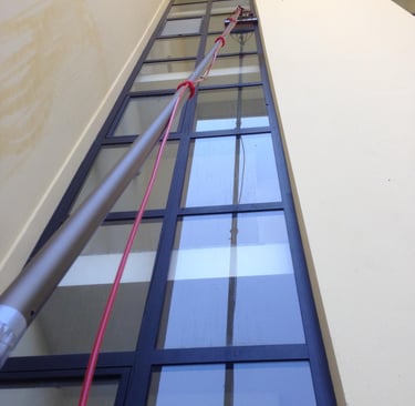 "Technicien professionnel utilisant un Perches Télescopiques spécialisé pour le nettoyage de vitres sans traces, eau osmosée