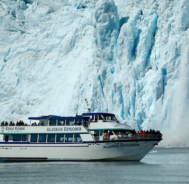 The Alaskan Explorer tour boat cruises past a massive calving glacier in Kenai Fjords National Park.