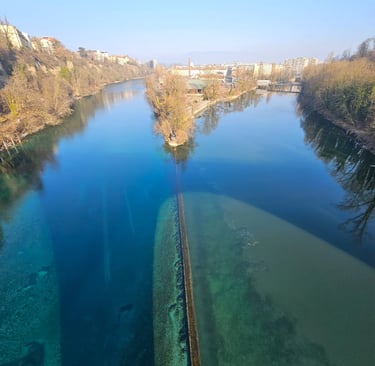 a river with a long line of water and a bridge