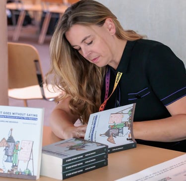 a woman is sitting at a table with books and a book