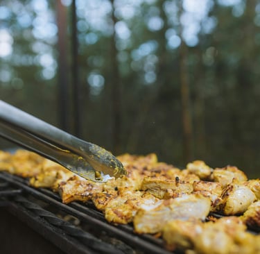 Chicken fillets being grilled outdoors