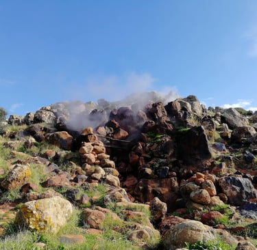 Favara Grande in Pantelleria with steam rising among volcanic rocks and natural vegetation