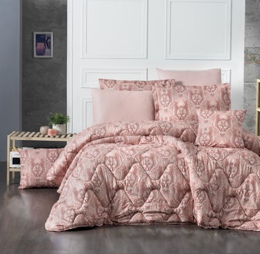 a bed with a pink comforter and pillows