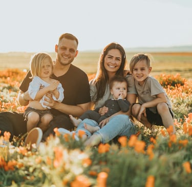 happy man and his family in a field of flowers