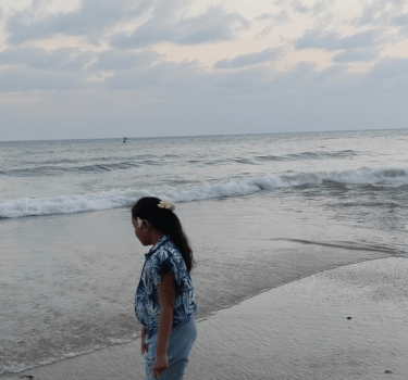 a woman standing on a beach with a kite kite