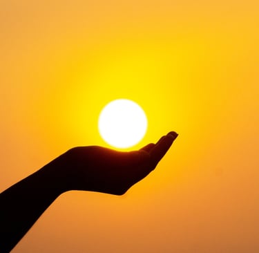 A cupped hand under a white sunlight with yellow glow