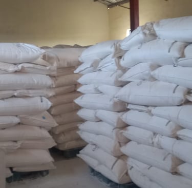 Stacks of white Tapioca Starch bags on pallets in a storage warehouse facility.