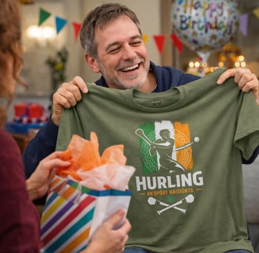 Smiling man opening a gift containing a green Irish hurling t-shirt at a birthday party.