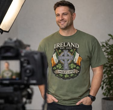 A smiling man wearing an olive green Ireland Celtic cross t-shirt on a professional video set.
