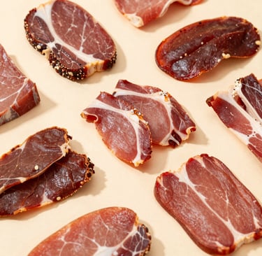 Artisanal dried meat strips with chili flakes on a dark slate plate