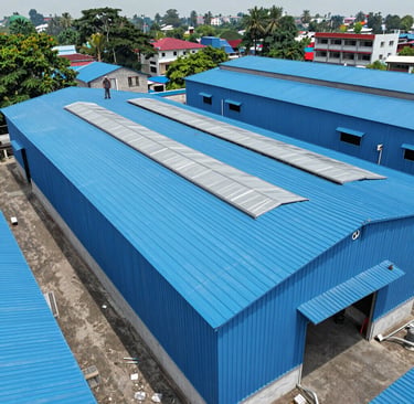 A modern industrial facility with a freshly completed metal sheet roof, showcasing the clean, professional finish.