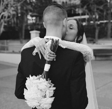 a bride and groom kissing in a city