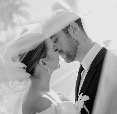 a bride and groom kissing in a veiled veil