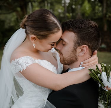 a bride and groom kissing in a field