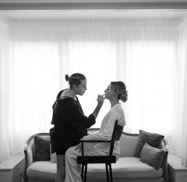 a makeup artist applying lipstick to a bride