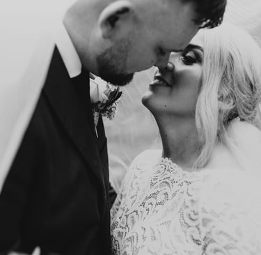 a bride and groom kissing in a black and white photo