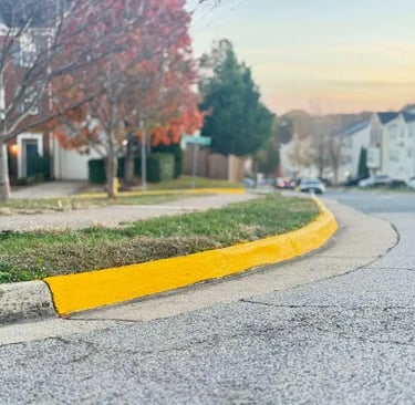 Fresh yellow curb paint in a residential community, highlighting improved visibility and fire lane