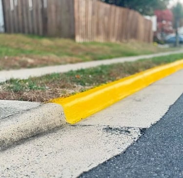 Yellow curb and fire lane striping in a residential community, showing fresh traffic paint