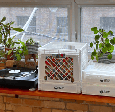 a record player's turntables on a table with a vinyl record storage crate