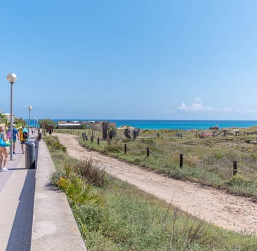 a group of people walking down a path at Cala mesquida, Mallorca