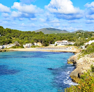 a view of a cala romantica beach in mallorca with a boat in the water