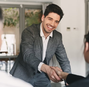 Professional person smiling and shaking hands during a meeting.