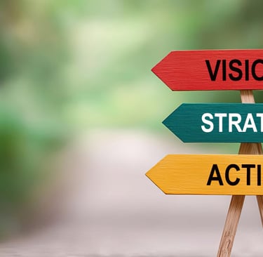 Signpost with three arrows labeled Vision, Strategy, and Action against a blurred outdoor background