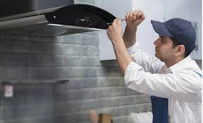 a man in a hat and a hat is fixing a stove top