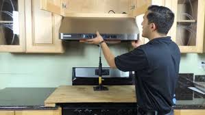 a man in a black shirt is holding a black and white microwave
