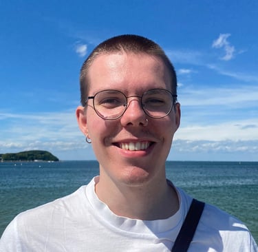 A photo of me smiling and standing in front of a sea