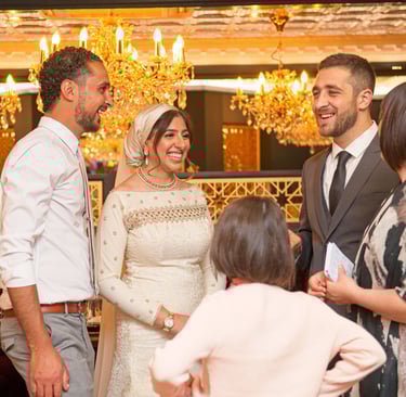 bride, groom and grooms man all laughing and smiling in a fancy restaurant