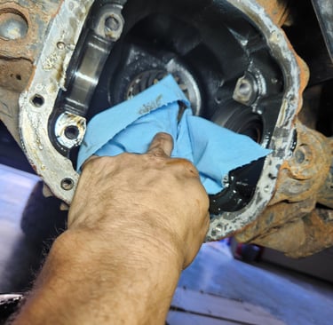 Fast T's Auto Technician cleaning a front differential with a blur cloth in preparation of an inner shaft seal replacement 