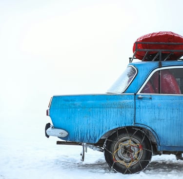 blue sedan with chain on tire parking on snowfield at daytime by Oziel Gómez 