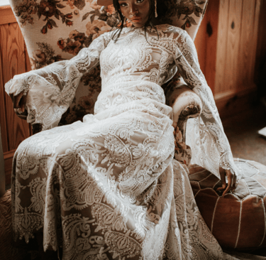 a woman in a white dress and hat sitting on a chair