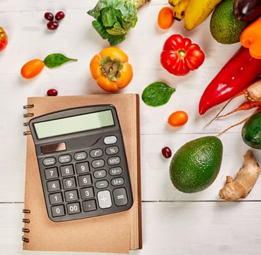a calculator with a notebook and scattered vegetables